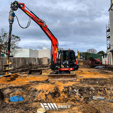 Tarière hydraulique sur un chantier